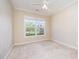 Neutral room featuring carpet flooring, large window, and ceiling fan at 8007 Crookneck Dr, Angier, NC 27501