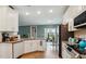 Bright kitchen with white cabinets, hardwood floors, and open layout to the dining area at 817 James J Freeland Memorial Dr, Hillsborough, NC 27278