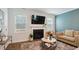 Cozy living room featuring a fireplace, large TV, and ample natural light at 817 James J Freeland Memorial Dr, Hillsborough, NC 27278