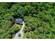 Expansive aerial view of a secluded house surrounded by a dense canopy of trees and well manicured grounds at 83 Calabria Ct, Clayton, NC 27527