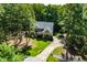 Stunning aerial view of a beautiful home nestled among mature trees with a long driveway at 83 Calabria Ct, Clayton, NC 27527