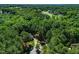 Aerial view of home nestled in a forest with neighboring homes in the distance at 83 Calabria Ct, Clayton, NC 27527
