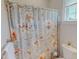 Floral shower curtain in a bright bathroom with a toilet and towel rack at 90 S Old Lantern Rd, Timberlake, NC 27583