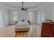 Bright main bedroom with hardwood floors, tray ceiling, ceiling fan, and access to the outdoors at 90 S Old Lantern Rd, Timberlake, NC 27583