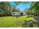 Exterior view of a home with a well-maintained lawn, patio area, and surrounding mature trees at 904 Lanier Farm Rd, Sanford, NC 27330
