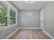 A bright bedroom featuring fresh paint and sleek vinyl floors showcases a door and natural light at 904 Lanier Farm Rd, Sanford, NC 27330