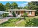 Inviting single-story brick home with a charming front porch and lush greenery at 904 Lanier Farm Rd, Sanford, NC 27330