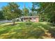 Inviting brick home with a well-kept lawn, flagpole, and trimmed trees enhancing its curb appeal at 904 Lanier Farm Rd, Sanford, NC 27330