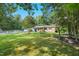 Charming home with a flagpole and lush green lawn, set back among mature trees at 904 Lanier Farm Rd, Sanford, NC 27330