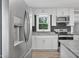 Bright kitchen with stainless steel appliances, granite countertops, white cabinets, and a window view at 904 Lanier Farm Rd, Sanford, NC 27330