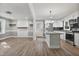 Open layout with white cabinets, black backsplash, island, stainless appliances, and floating shelves at 904 Lanier Farm Rd, Sanford, NC 27330