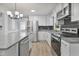 Modern kitchen with granite countertops, stainless steel appliances, black backsplash, and eat-in island at 904 Lanier Farm Rd, Sanford, NC 27330