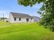 Backyard with a manicured lawn, patio, and view of the home's exterior and neighboring properties at 100 Haddonfield Ct, Franklinton, NC 27525