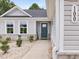 Inviting front entrance featuring a teal door, stone accents, and manicured landscaping at 100 Haddonfield Ct, Franklinton, NC 27525