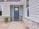 Inviting front entrance with a teal door, decorative stone accents, and a 'Summer' welcome sign at 100 Haddonfield Ct, Franklinton, NC 27525