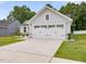 View of a two car garage with white doors, set against the home's light gray facade at 100 Haddonfield Ct, Franklinton, NC 27525