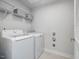 Bright laundry room features white washer and dryer, wire shelving, and tiled flooring at 100 Haddonfield Ct, Franklinton, NC 27525