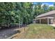 Spacious backyard with lush greenery and the rear of the house with covered patio at 101 Ferndale Ct, Clayton, NC 27520