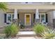 Inviting front porch featuring stone supports, white columns, a yellow front door, and cozy seating at 101 Ferndale Ct, Clayton, NC 27520