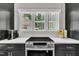 Bright kitchen featuring stainless steel stove and oven, black cabinetry, and a window with outdoor views at 101 Ferndale Ct, Clayton, NC 27520