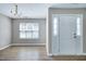 Inviting entryway with hardwood floors, a chandelier, a window, and a white door, creating a warm first impression at 103 Bermuda Green Dr, Durham, NC 27703