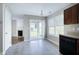 Bright eat-in kitchen featuring sliding glass doors, tile floors, and an adjoining living room with fireplace at 103 Bermuda Green Dr, Durham, NC 27703