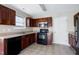 Well-equipped kitchen featuring dark wood cabinets, stainless steel microwave, and tile flooring for easy maintenance at 103 Bermuda Green Dr, Durham, NC 27703