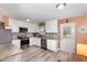 Bright and airy kitchen featuring stainless steel appliances, gray backsplash, and white cabinetry at 11 Sherman Rd, Fuquay Varina, NC 27526