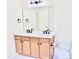 Bathroom features double sinks, quartz countertop, modern lighting, and wood cabinets at 1121 Brookhill Way, Cary, NC 27519