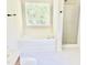 Bright bathroom with a soaking tub under a window and glass shower with black hardware at 1121 Brookhill Way, Cary, NC 27519
