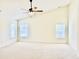Bright bedroom with vaulted ceiling, ceiling fan, large windows offering ample natural light, and neutral colored carpet at 1121 Brookhill Way, Cary, NC 27519