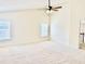 Spacious bedroom featuring neutral carpeting, a modern ceiling fan, and ample natural light through large windows at 1121 Brookhill Way, Cary, NC 27519