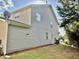 Back exterior view showing neutral siding, well-kept lawn and access door at 1121 Brookhill Way, Cary, NC 27519