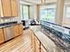 Kitchen with stainless steel dishwasher, marble countertops, and light-filled windows at 1121 Brookhill Way, Cary, NC 27519