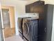 Convenient laundry room includes modern black washer and dryer, cabinets, and access to bathroom at 1121 Brookhill Way, Cary, NC 27519