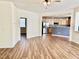 Open-concept living room with wood floors leading to the kitchen at 1121 Brookhill Way, Cary, NC 27519