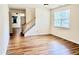 An empty living room with laminate flooring and an open staircase at 1121 Brookhill Way, Cary, NC 27519