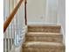 Stairway with white railing and neutral carpeting, leading to the upper level at 1121 Brookhill Way, Cary, NC 27519