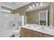 Well-lit bathroom with a dual sink vanity, bathtub and shower combination, and neutral color palette at 11309 Shadow Elms Lane Ln, Raleigh, NC 27614
