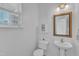 Bright bathroom featuring window, pedestal sink, and toilet at 11309 Shadow Elms Lane Ln, Raleigh, NC 27614