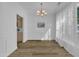 Modern dining room with wood-look floors, stylish chandelier, and an open view to the kitchen at 11309 Shadow Elms Lane Ln, Raleigh, NC 27614