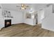 Open-concept living space featuring wood-look floors, a cozy fireplace, and seamless flow to the kitchen at 11309 Shadow Elms Lane Ln, Raleigh, NC 27614