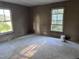 Bedroom with natural light from windows and beige walls awaiting restoration at 12670 School House Rd, Middlesex, NC 27557
