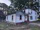 Two-story house with white siding, showing the house's back side to be restored at 12670 School House Rd, Middlesex, NC 27557