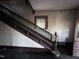 Staircase with wooden banister, landing, and a window to be restored at 12670 School House Rd, Middlesex, NC 27557