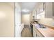Galley kitchen featuring white cabinets, wood-look countertops, stainless steel sink and updated flooring at 1320 Park Glen Drive Dr # 204, Raleigh, NC 27610