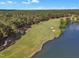 Aerial view of a golf course and pond surrounded by lush trees, showcasing scenic recreation in the community at 1326 Fairview Club Dr, Wake Forest, NC 27587