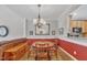 Dining room with wooden table and red accent wall with hutch and view of the kitchen sink at 1326 Fairview Club Dr, Wake Forest, NC 27587
