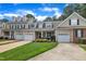 A beige townhome features an attached garage, a front lawn, and a driveway at 1326 Fairview Club Dr, Wake Forest, NC 27587