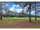 Beautiful golf course view with lush green grass and mature trees under a partly cloudy blue sky at 1326 Fairview Club Dr, Wake Forest, NC 27587